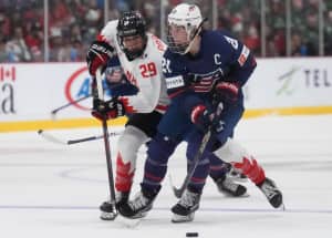 Two hockey players compete for the puck.