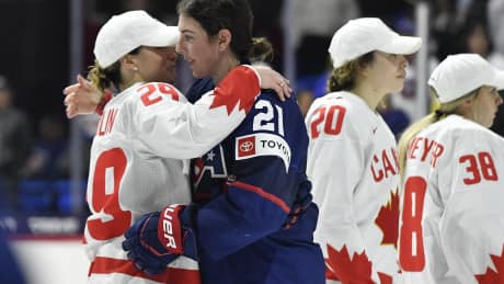 Two hockey players hug.