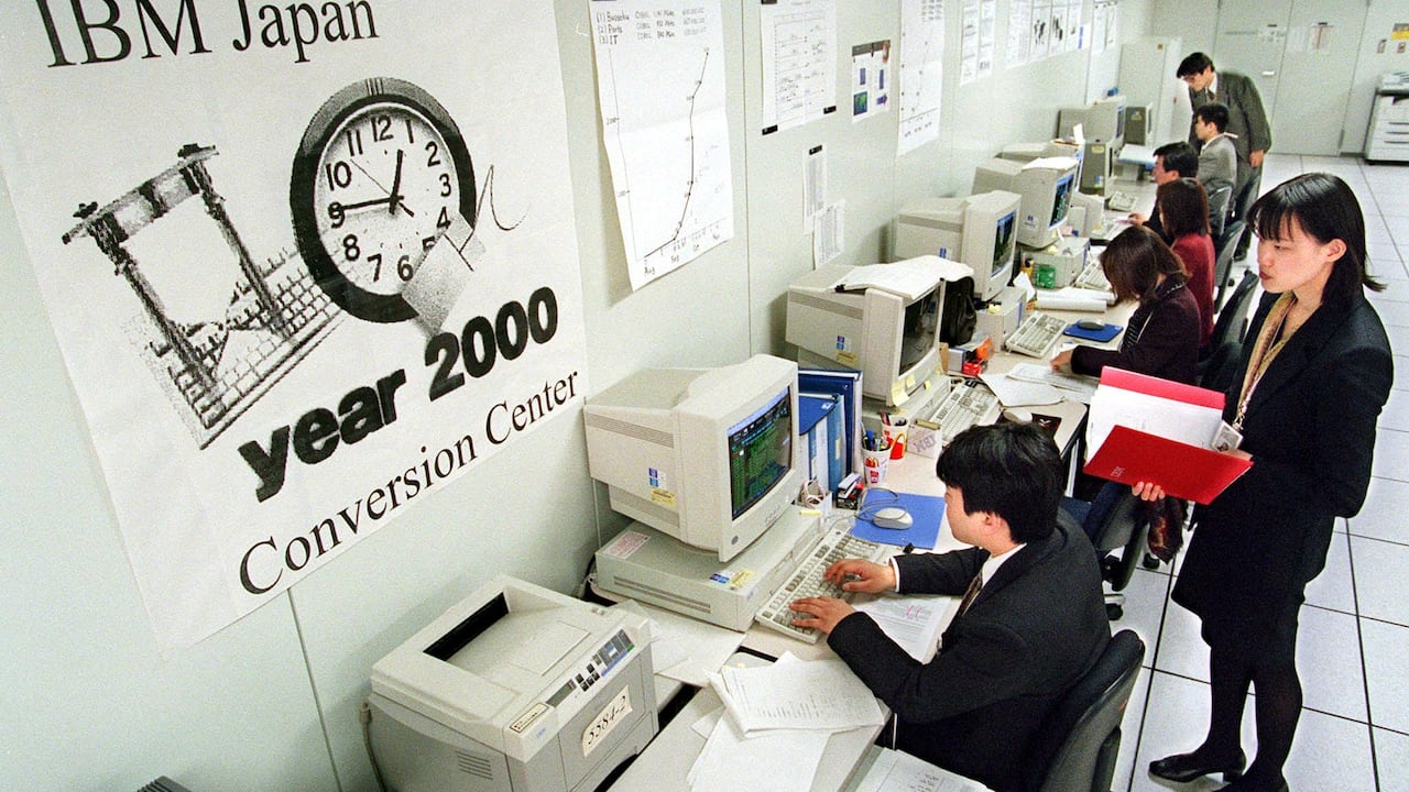Several people sit on computers in the year 2000.