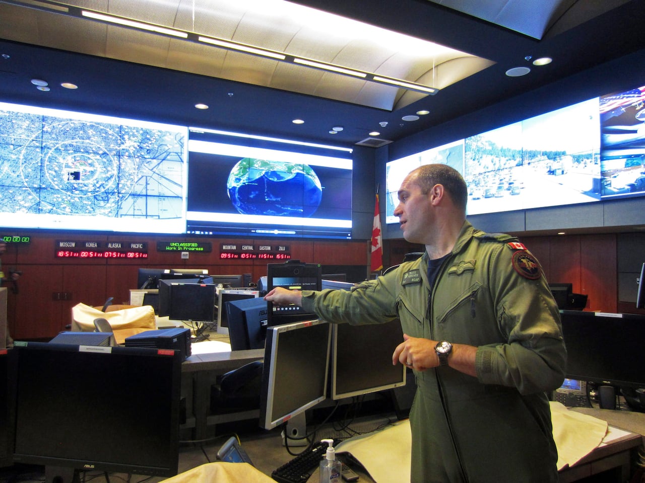 A person in military garb is seen inside a command centre.
