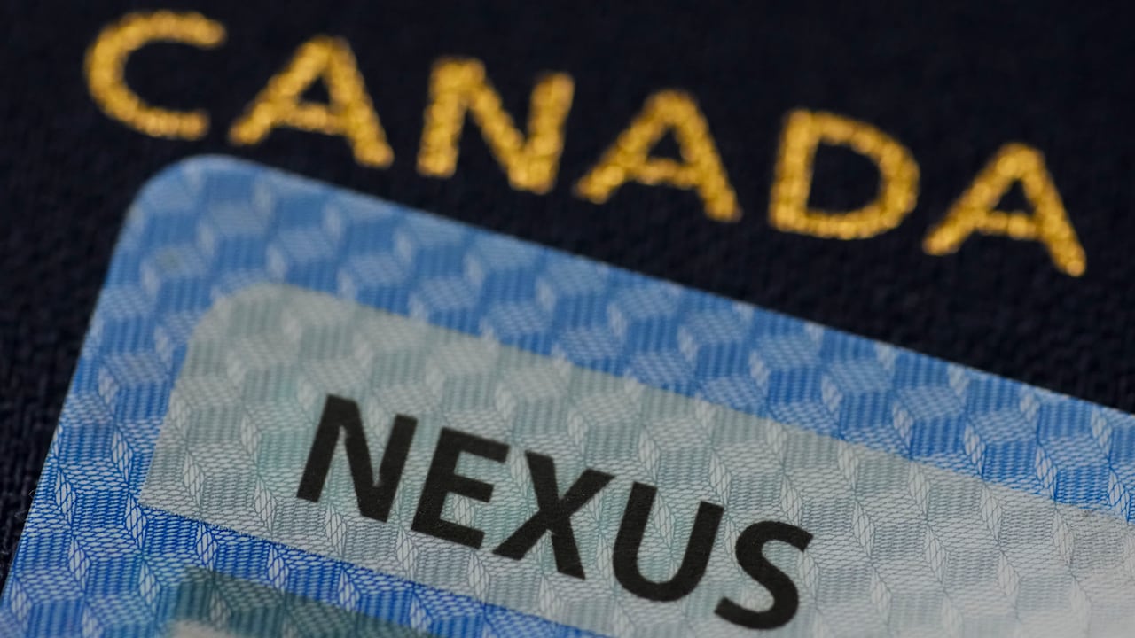 A Nexus card is placed over a Canadian passport.