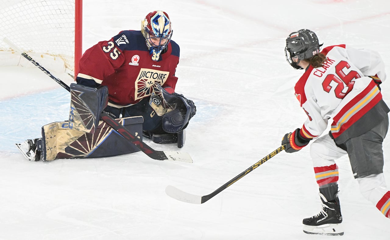 A hockey goalie representing the Montreal Victoire makes a save.