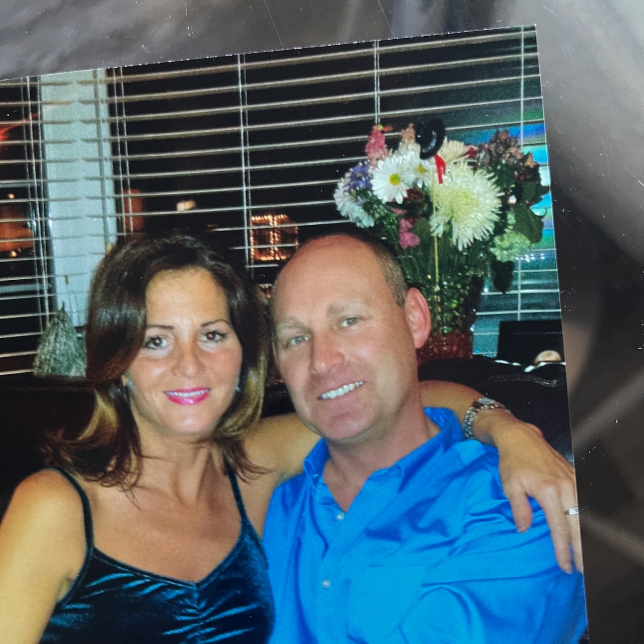 A man and a woman are wrapped up together and smiling at the camera.