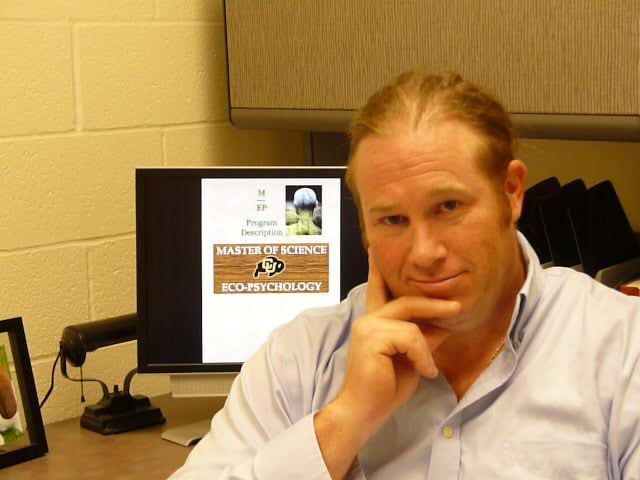 A man sits in office in front of a computer